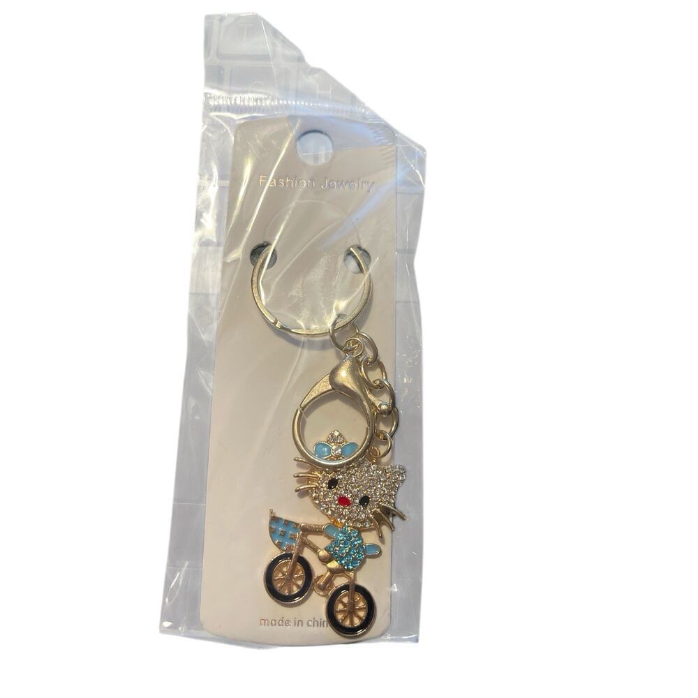 FASHION JEWELRY KITTY ON BIKE GOLD PLATED WITH CLEAR AND BLUE SPARKLES KEYCHAIN